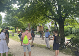Eine Gruppe von Menschen vor einem Spielplatz im Park in Mahlberg bei einem Hitzespaziergang.